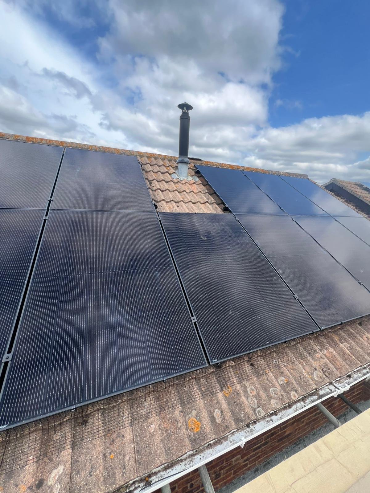 Solar panels installed neatly around a roof flue in Winchester