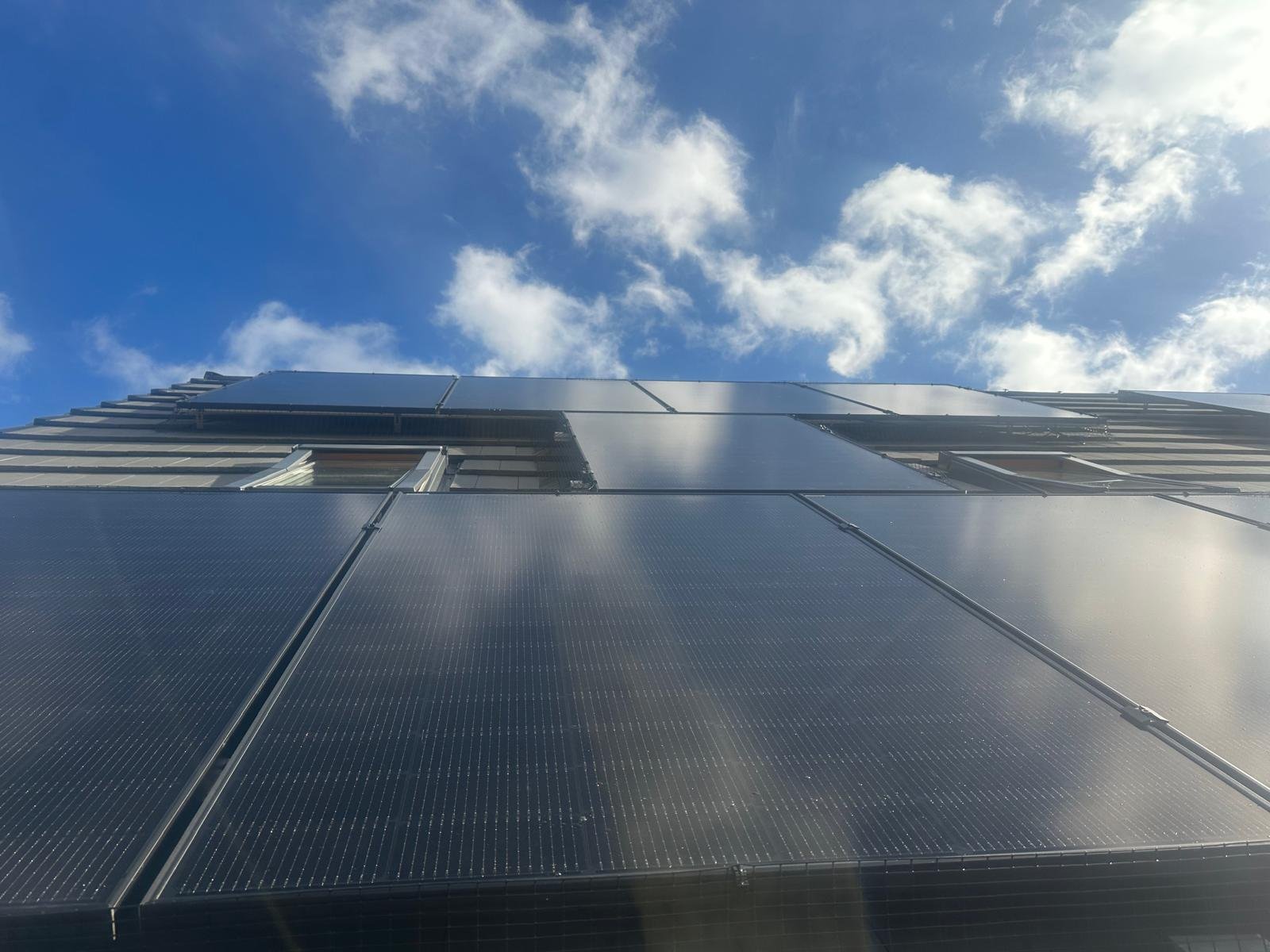 Black solar PV panels against a blue sky on a Winchester rooftop