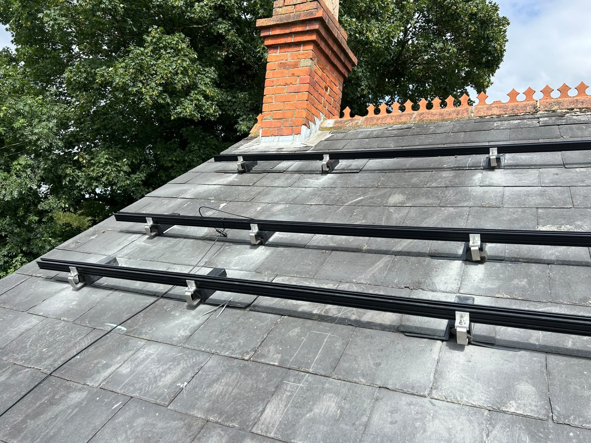 Solar panel mounting rails and roof hooks fitted to a slate roof
