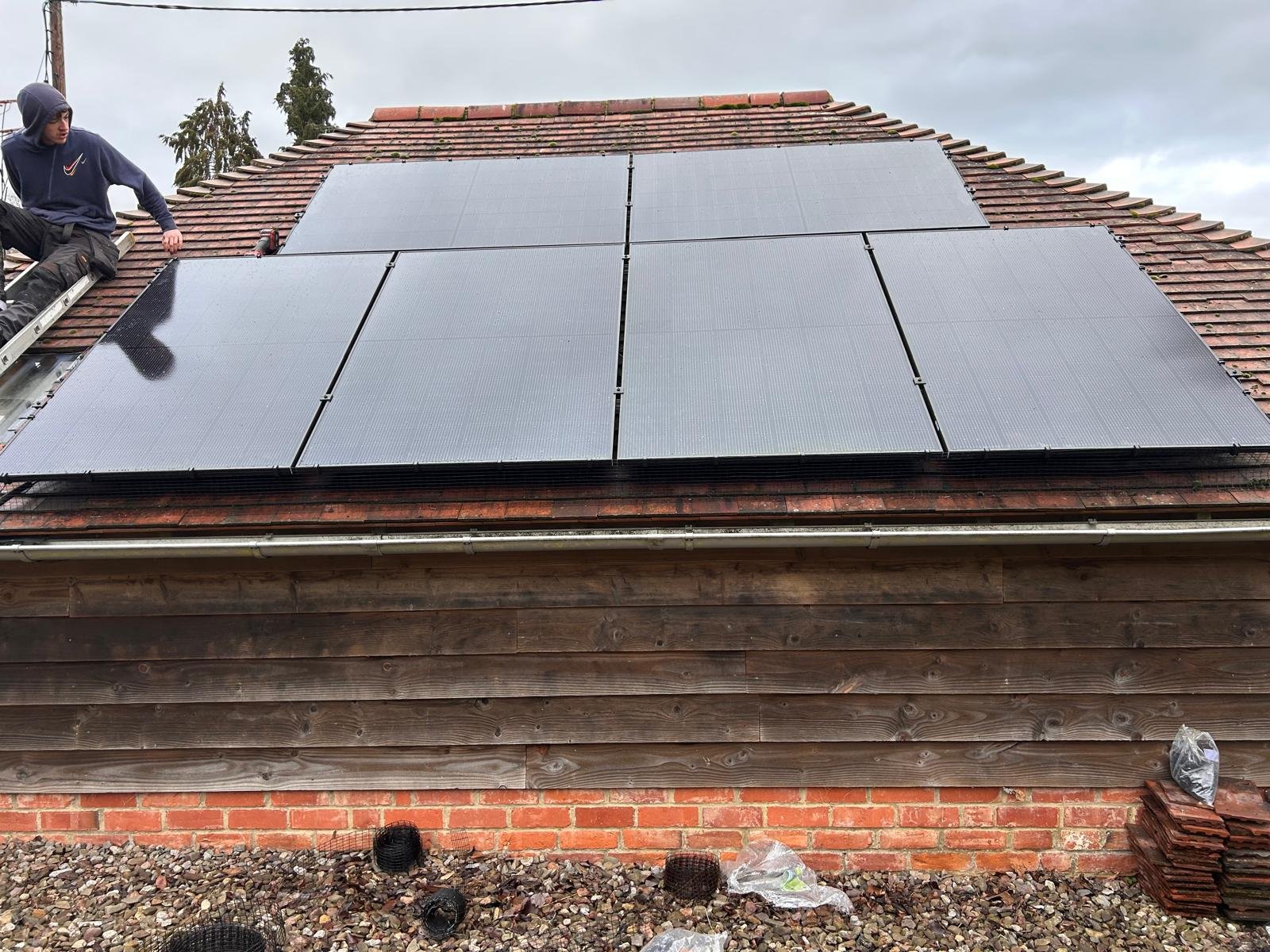 Solar panels being installed on a wood-clad building in Hampshire