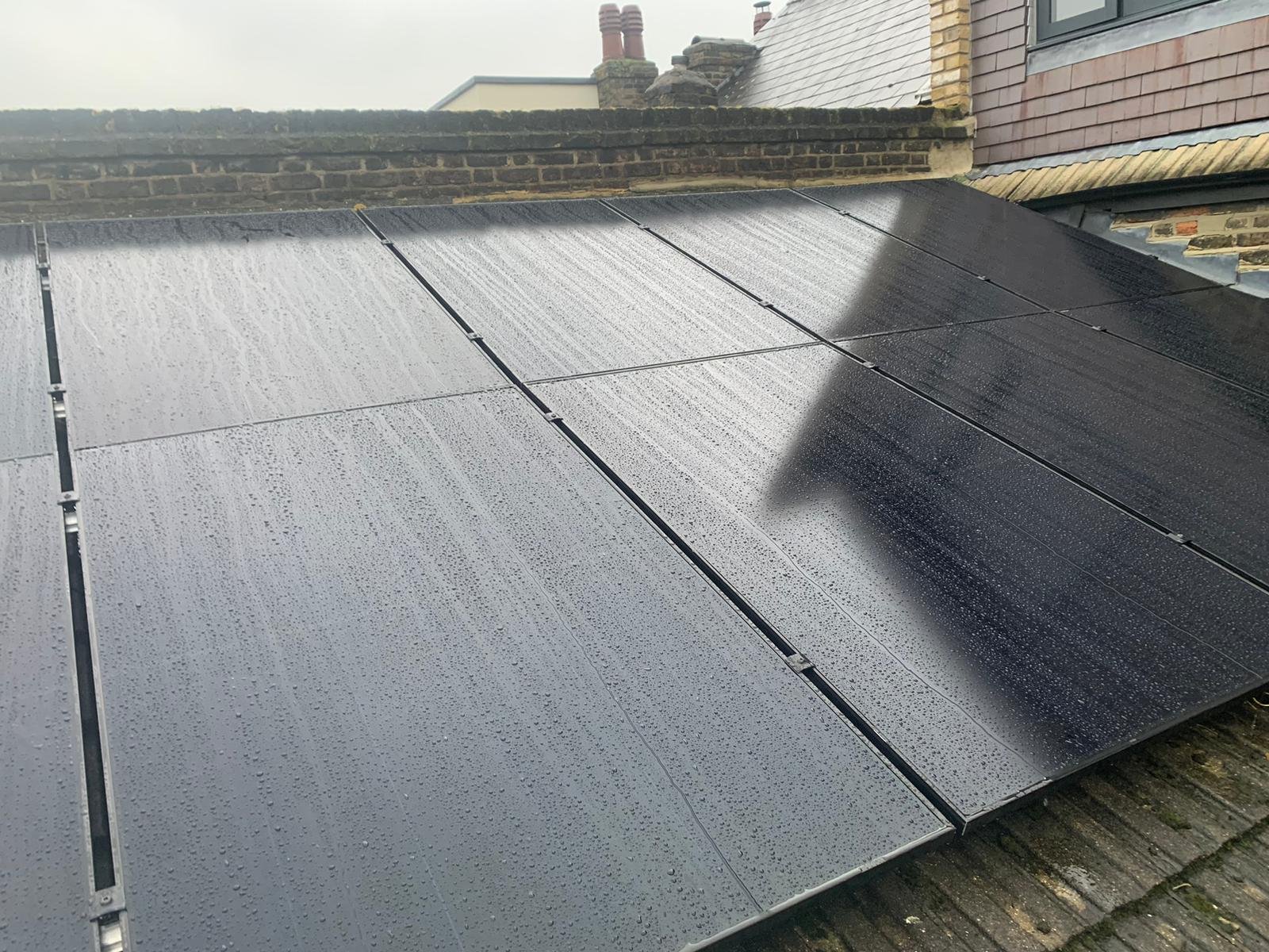 Rainwater beading on a low-pitch solar panel array in Hampshire