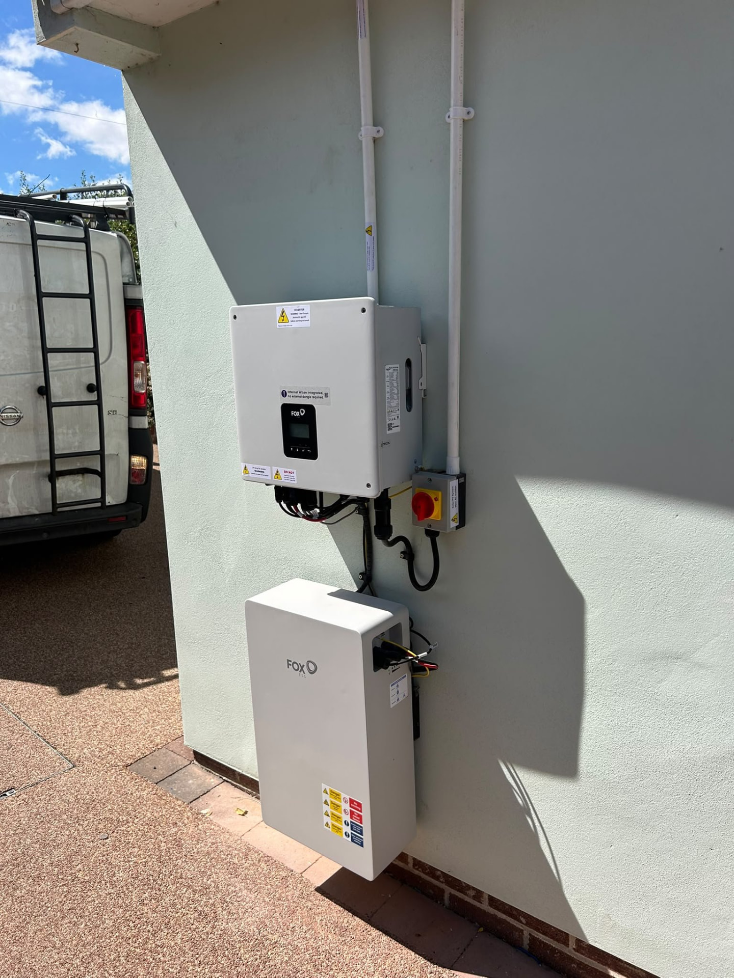 Outdoor Fox ESS inverter and battery on a rendered wall in Winchester