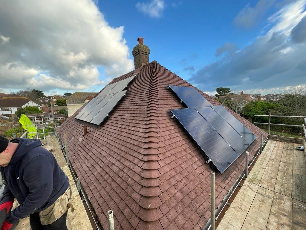 Solar PV panels fitted to a hipped tiled roof with scaffolding in place in Hampshire